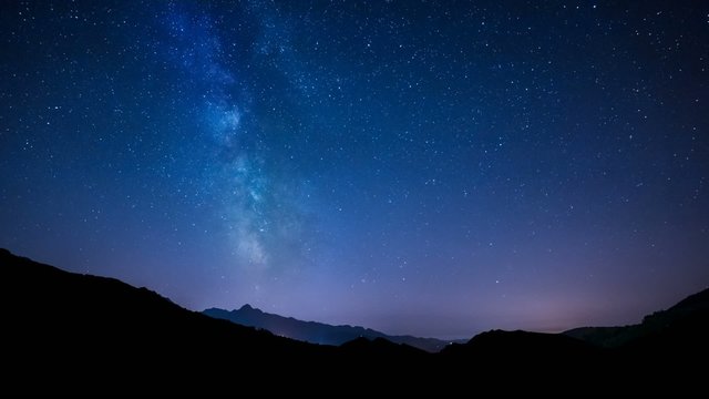 timelapse night sky stars milky way on mountains background.