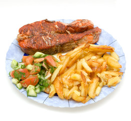 fried trout steak on a plate with potato and vegetable salade