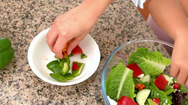 Mother and daughter preparing salad together