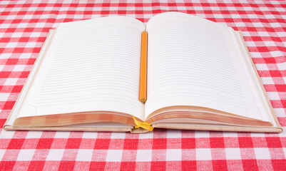 Notebook with pencil on a tablecloth vichy