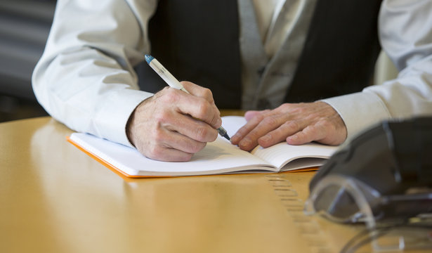 close-up of man's hands signing a paper