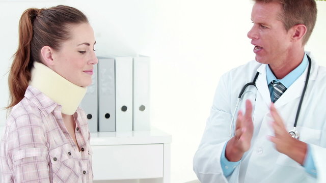 Doctor speaking with patient in neck brace