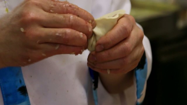 Chef hand preparing dough with rolling pin for asian food on