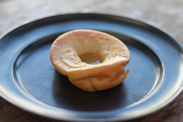 One piece of yorkshire pudding on a tin plate.