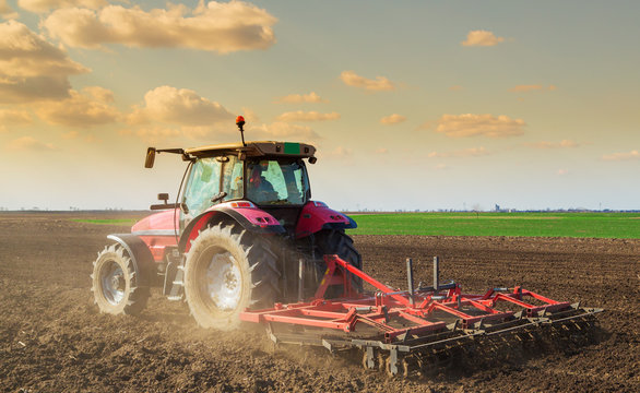 Farmer in tractor preparing land with seedbed cultivator
