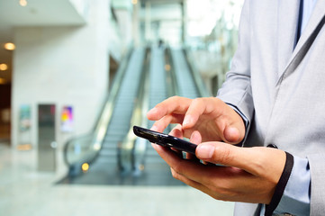 Business Man Using Mobile while going down Escalator