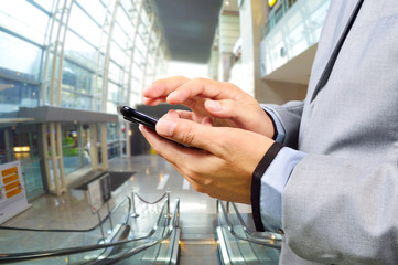 Business Man Using Mobile while going down Escalator