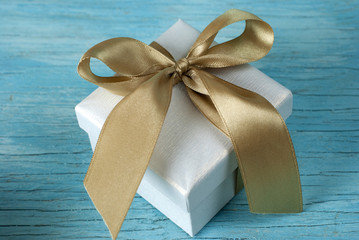 Gift box with ribbon on old wooden table