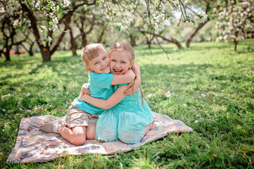 Fototapeta premium happy brother and sister having fun in spring apple garden