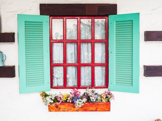 opened wooden shutter light green window on white wall with flow