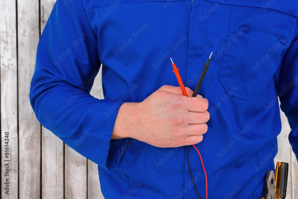 Poster composite image of electrician holding multimeter