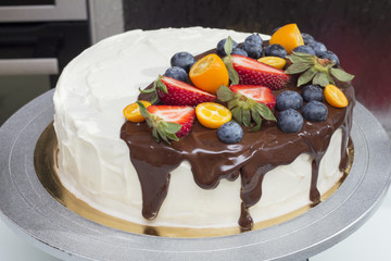 Beautiful colorful cake with berries drizzled with chocolate