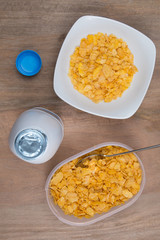 Cornflakes with milk, eggs,  on a wooden brown background