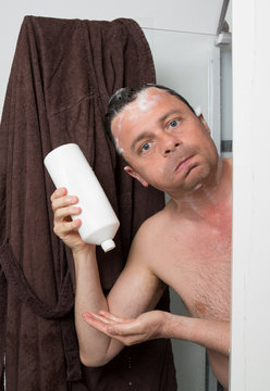Man with shampoo in his hair in hi s bathroom