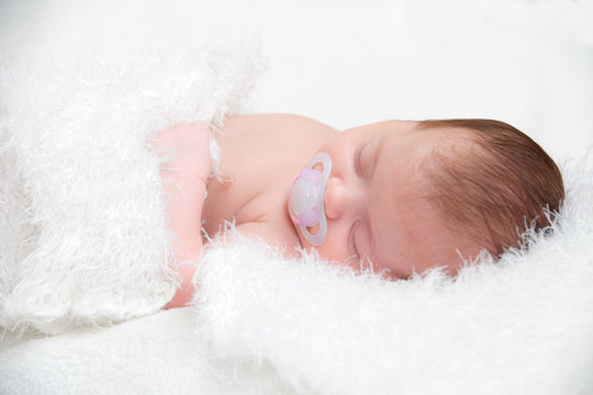picture of a newborn baby curled up sleeping