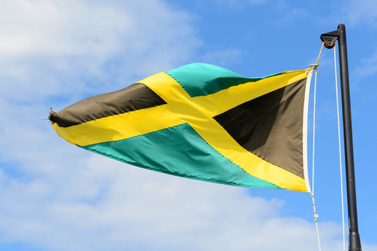 Flag of Jamaica waving against blue sky