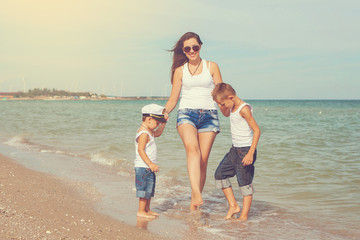 Mother and her two sons having fun on the beach