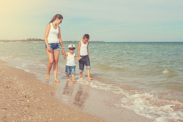 Mother and her two sons having fun on the beach