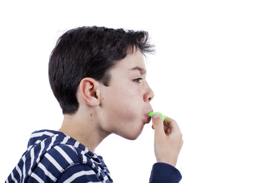 Ni&ntilde;o soplando pito verde