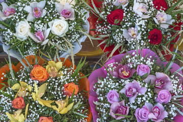 Different colour bouquets of flowers on display on a market stal