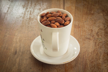 Fresh salted almonds in white ceramic glass (soft focus)