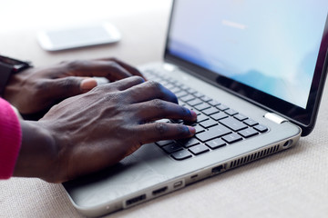 Handsome young man working with his laptop at home.