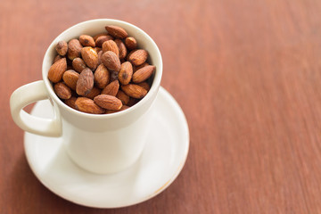 Fresh salted almonds in white ceramic glass (soft focus)