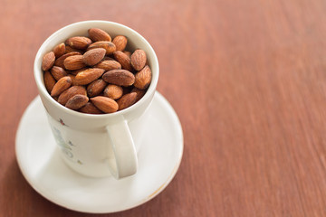 Fresh salted almonds in white ceramic glass (soft focus)