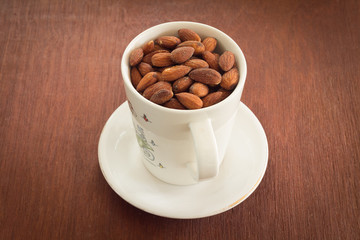 Fresh salted almonds in white ceramic glass (soft focus)