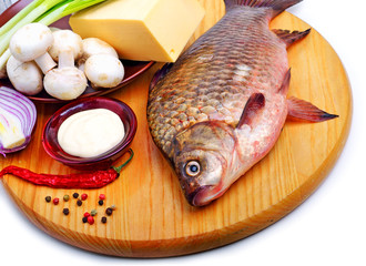 Baked fish with vegetables, sauce, red pepper on cutting board