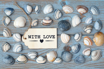 Wooden background with sea shells and with love label