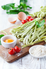 Fresh pasta tagliatelle with spinach leaves, vegetables and eggs