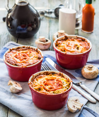 mushroom julienne with tomato and cheese in red pots