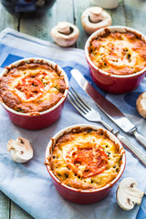 mushroom julienne with tomato and cheese in red pots