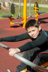 Fototapeta premium The boy on outdoor sport ground / gym