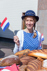 Woman with breads waving with dutch flag