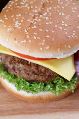 Hamburger with grilled meat and cheese on a wooden surface 

