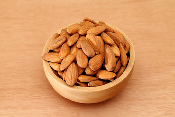 Fresh almonds in a wooden bowl - 81631239