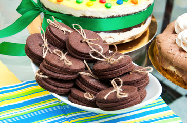 Sugar cookies in shape of buttons on a table covered with bright