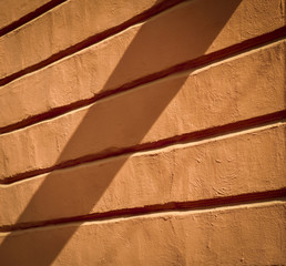 old orange wall with relief in the shade