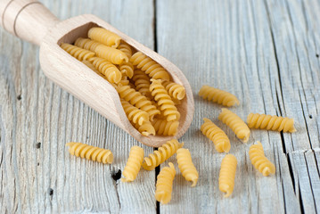 Fototapeta na wymiar Uncooked fusilli pasta on old wooden table