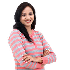 Portrait of young happy woman standing with arms crossed against