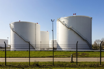 white tanks in tank farm with iron staircase