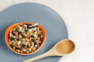 legumes in a dish on wood, with spoon, close up, background