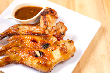 Fried chicken wings with spicy sauce on wooden table