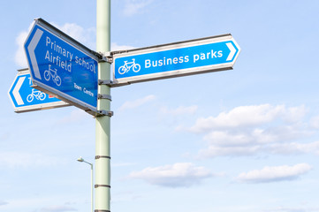 Sign post for Business Parks, Primary School, Airfield, Cyclist