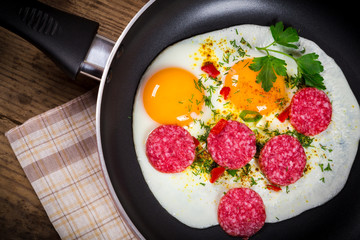 fried eggs with sausage in pan