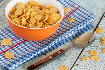 Bowl of corn flakes on old wooden table