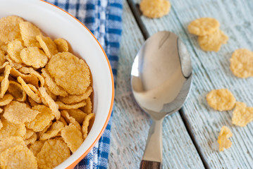 Bowl of corn flakes on old wooden table