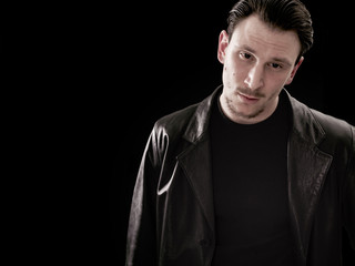 Handsome and thoughtful man portrait on black background